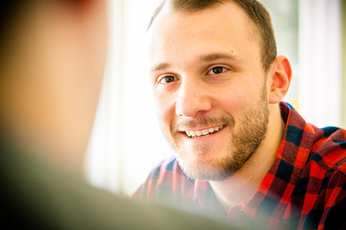 Happy male client talking to blurred rear view of life coach